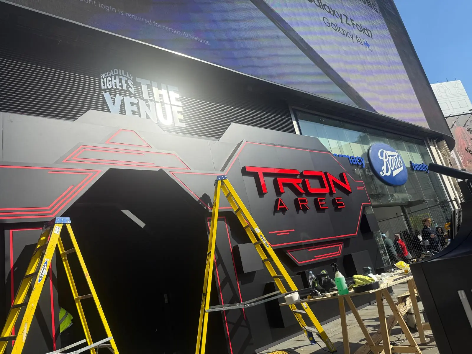 Large black and red entrance sign for Tron Ares at Piccadilly Lights being installed.