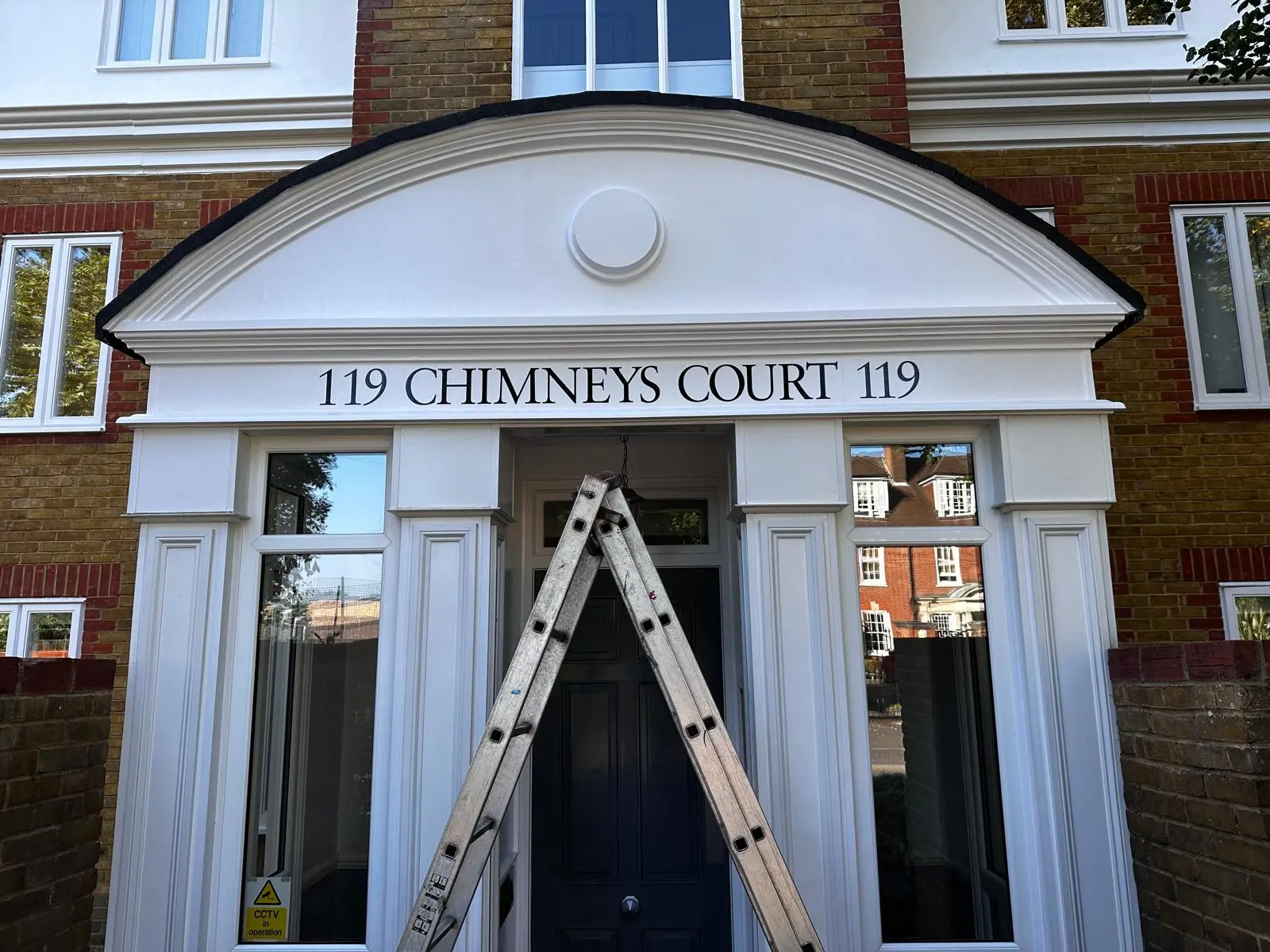 Elegant white entrance sign for '119 Chimneys Court 119'.